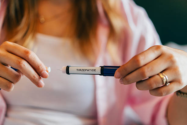Woman holding a tirzepatide pen before her first weekly dose